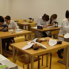 Grupa uczniów w ławkach przy binokularach